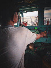 boat driver in wheelhouse, east kalimantan, indonesia, december 13, 2022 © light stock