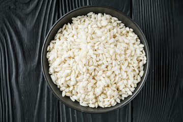 arborio rice for risotto on a black wooden background