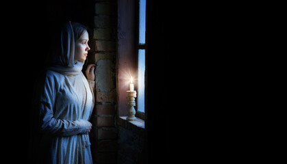 Young girl at the old wooden window