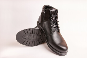 Black leather men's boots on a white background. Warm shoes for winter.