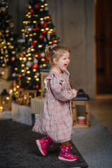 Fototapeta na wymiar A young girl lives in Christmas decorations