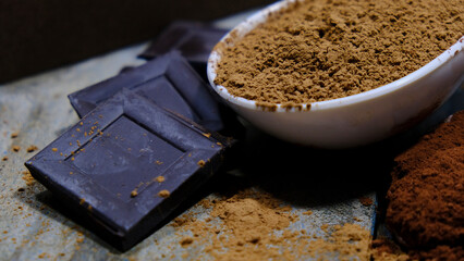 Algarrobo en polvo, cacao puro en polvo y chocolate en fondo oscuro. Darckfood