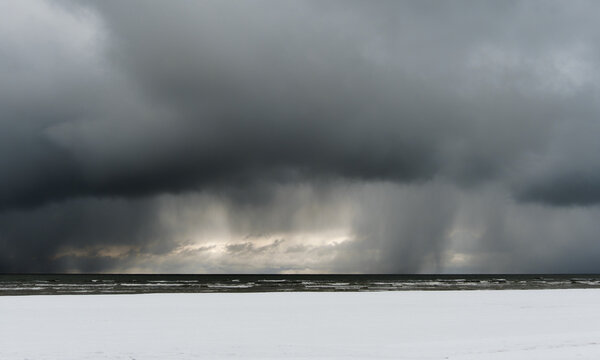 Baltic Sea beach in snowy winter. Falling snow from the clouds. © Igor