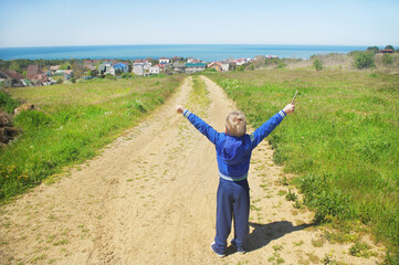 A little boy stands on the road