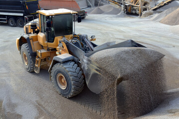 Wheel loader excavator unloading sand