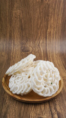Kerupuk is a traditional snack from Indonesia on wooden background. Selective focus