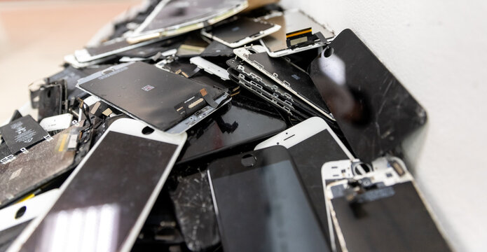 Broken iPhone Apple phone screens and used rechargeable batteries in recycling repair shop, RUSSIA - July 27, 2020