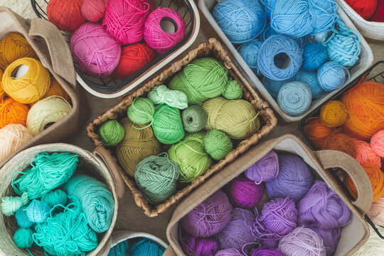 Many baskets made of natural eco-friendly materials. Multicolor yarn for knitting, knitting needles 