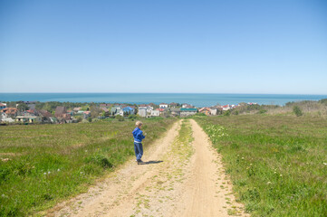 A little boy stands on the road