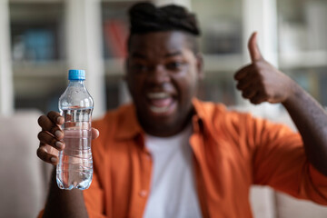 Fototapeta na wymiar Black man holding water bottle and thumb up