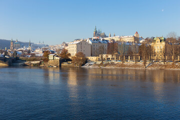 Obraz premium Snowy Prague Lesser Town with Prague Castle above River Vltava in the sunny Day , Czech republic