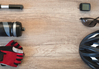Cycling things around the edges on a brown wooden background. Sporty lifestyle concept with space for text