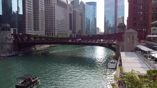 Aerial down row of bridges through the Chicago ship canal surrounded by skyscrapers