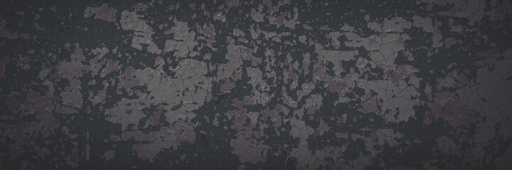 Dark wide panoramic background. Peeling paint on a concrete wall. Faded dark texture of old cracked flaking paint. Weathered rough painted surface with patterns of cracks. Shaded background for design