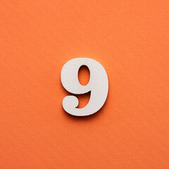 Number nine - white number in wood on pink background