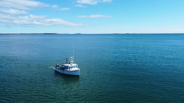 Aerial pan around Fishing boat for lobster and clams on Maine ocean