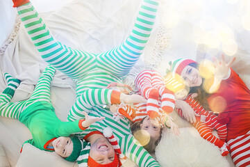 christmas pajama striped party family with kids, new year costumes, fun at home in bed