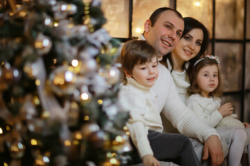 family with small children new year tree, december holidays at home