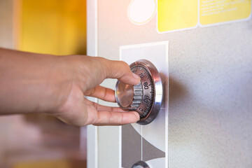 plate safe lock combination. Close up of a woman hand hold and tuning on a combinations safe dial...