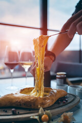 person mixing suluguni cheese and egg yolk in georgian adjarian khachapuri