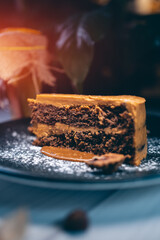 closeup of chocolate nut cake with walnut and physalis on dark plate