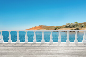 Outdoor wooden terrace revealing picturesque view on sea under blue sky