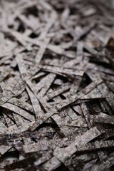 Chopped crispy nori sheets as background, closeup