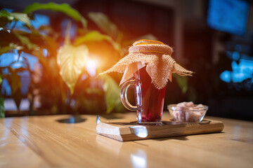 vitamin red pomegranate or berry tea cup with basil, pink sugar on wooden table