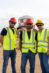 Portrait of three industrial workers standing on a construction site
