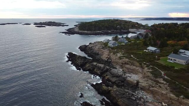 Aerial over coast of Maine with rocky cliffs and homes