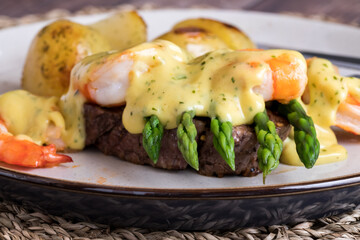 A plate of Steak Oscar with jumbo prawns and served with roasted potatoes.