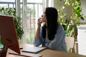 Procrastination in online learning. Dreamy Asian student girl getting distracted while studying...
