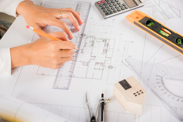 Architectural project workplace. Architect drawing with ruler on house plan blueprint paper for repair tools on table desk at architecture office, architect sketching construction, Engineering tools