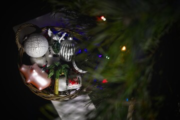 Vintage Christmas decorations in round baskets and glass balls in a box under the Christmas tree. - 553626542