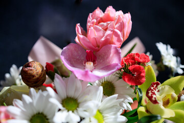 beautiful bouquet of different flowers close-up on a dark background - 553626577
