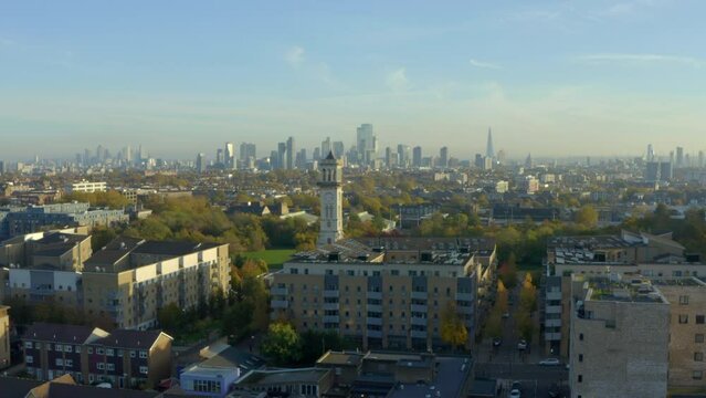 Drone shot passed Caledonian Park Clock Tower towards London skyscrapers and Smithfield market