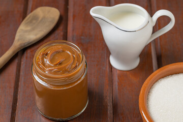 Dulce de leche, traditional sweet from Argentina on wooden table.
