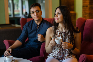 young man and woman happy couple having cup of coffee at home or cafe