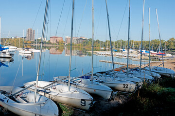 Lake Bde Maka Ska (was Lake Calhoun) quiet and calm with sailboats anchored in the water and moored on the shore. Minneapolis Minnesota MN USA