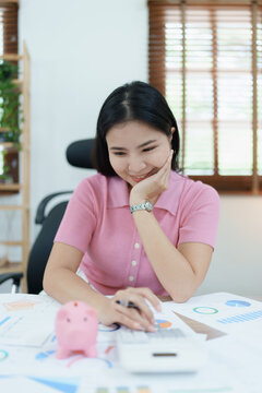 investment plan, young asian woman keep coin money in jar and using calculator to calculate savings
