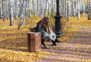 A girl on a bench in an autumn park