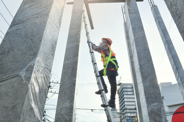 Side view of worker engineer in safety helmet climbing the ladder to get to the top . worker...