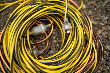 extension cord wrapped up on the ground. extension lead, power lead