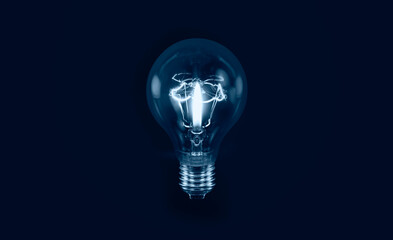 Burning candle in the light bulb  isolated on black background