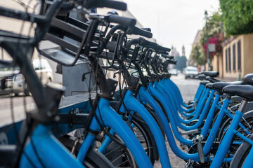 Row of bicycles on the docking station, public bike-sharing mobility system