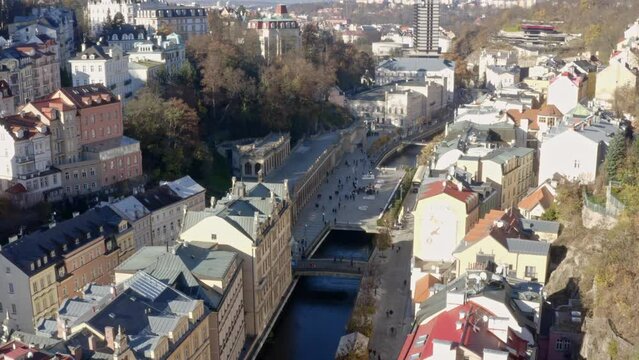 Tepl&aacute; river canal flowing through sunlit Carlsbad spa town in Czechia.