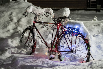 Bike in the snow on the street. The bike is decorated for the New Year