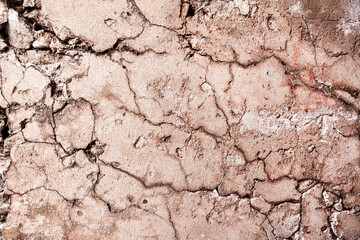 Cracked concrete wall covered with orange cement texture as background.
