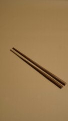 Two chopsticks on a empty brown background