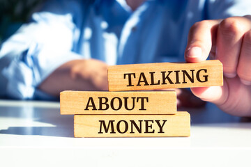 Wooden blocks with words 'Talking About Money'.